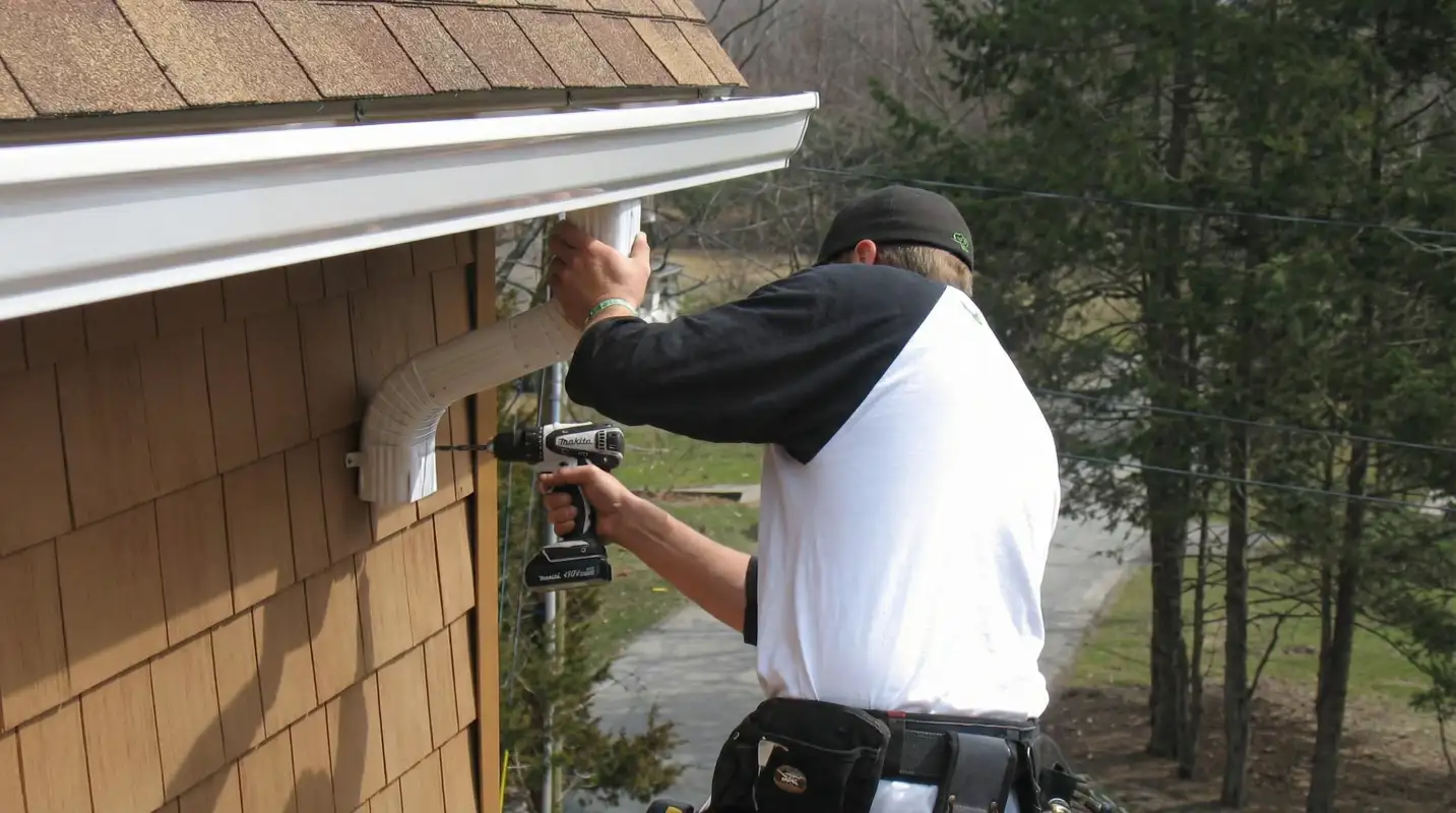 Professional contractor installing tan vinyl siding panels on a residential home exterior in Memphis, TN
